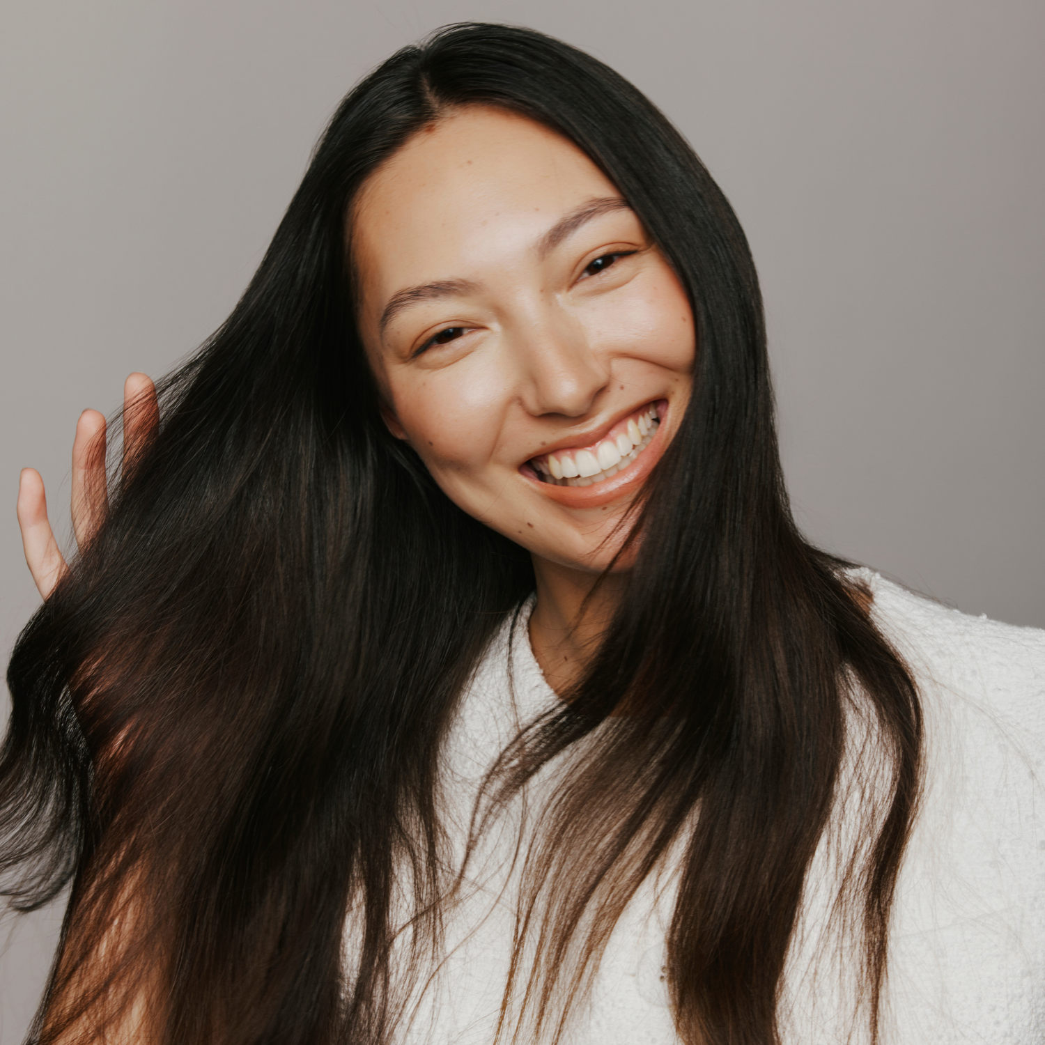 Model with shiny, smooth hair after using CZE Hair Nourishing Perfume Oil – lightweight leave-in treatment